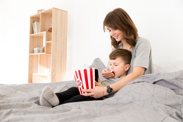 Mamma dell'angolo alto che alimenta il suo popcorn del figlio