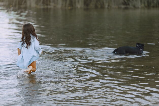 Mamma e figlia in abiti identici. Famiglia che gioca in riva al fiume.