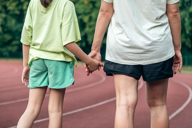 Mamma e figlia si tengono per mano allo stadio