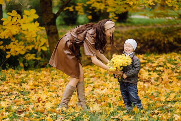 Mamma e figlio che camminano e si divertono insieme nel parco d'autunno.