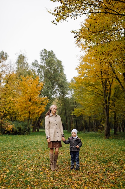 Mamma e figlio che camminano e si divertono insieme nel parco d'autunno.