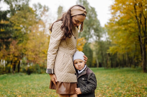 Mamma e figlio che camminano e si divertono insieme nel parco d'autunno.