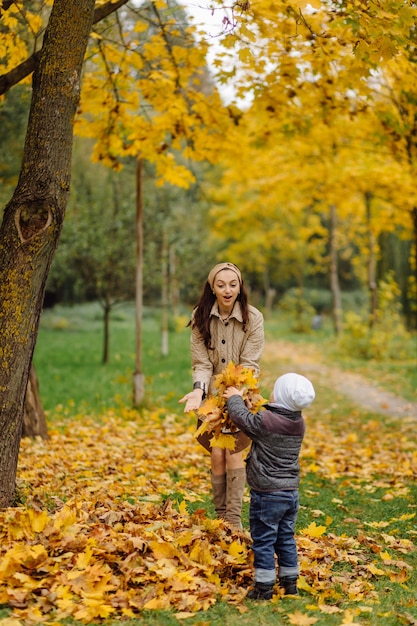 Mamma e figlio che camminano e si divertono insieme nel parco d'autunno.