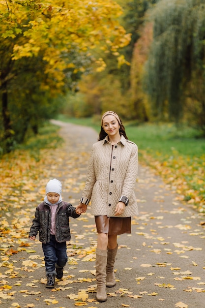 Mamma e figlio che camminano e si divertono insieme nel parco d'autunno.