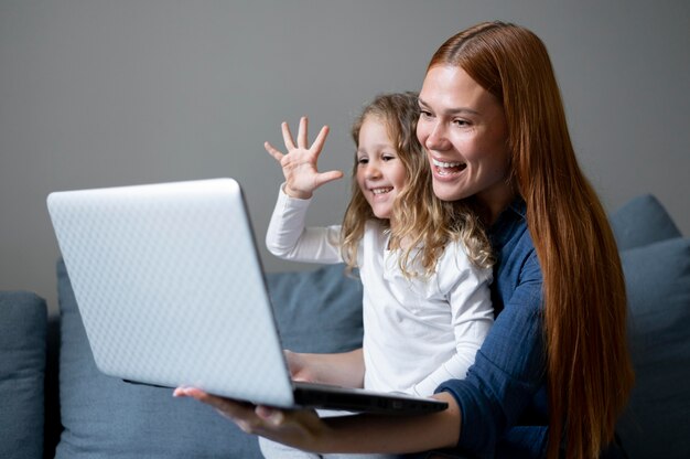 Mamma fa una videochiamata di famiglia con sua figlia