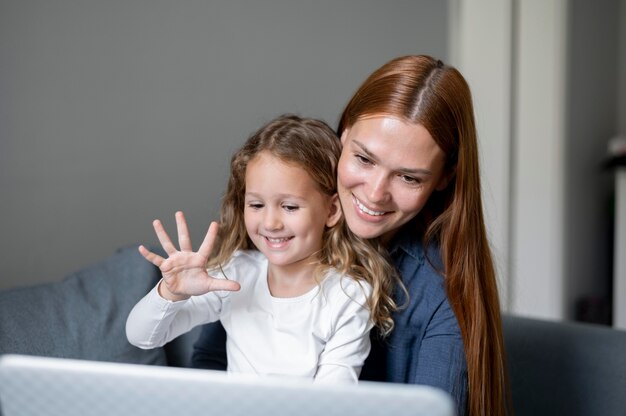 Mamma fa una videochiamata di famiglia con sua figlia