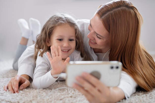 Mamma fa una videochiamata di famiglia con sua figlia