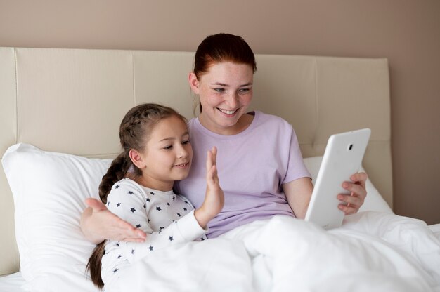 Mamma fa una videochiamata di famiglia con sua figlia