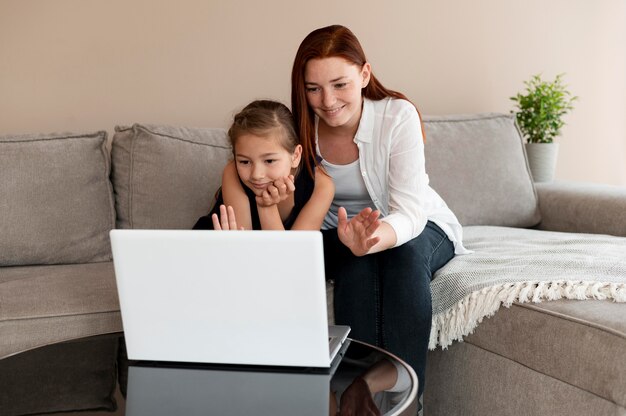 Mamma fa una videochiamata di famiglia con sua figlia
