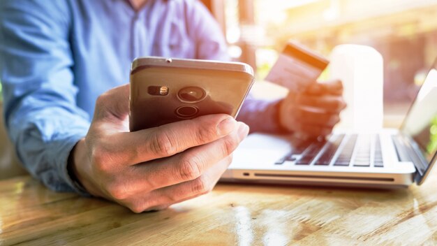 Man holding carta di credito in mano e l&#39;immissione di codice di sicurezza utilizzando la tastiera del computer portatile