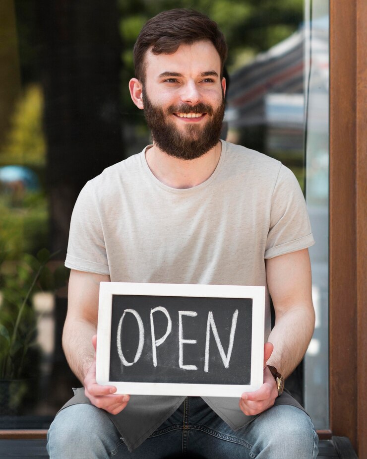 Foto gratuito man holding siamo segno aperto