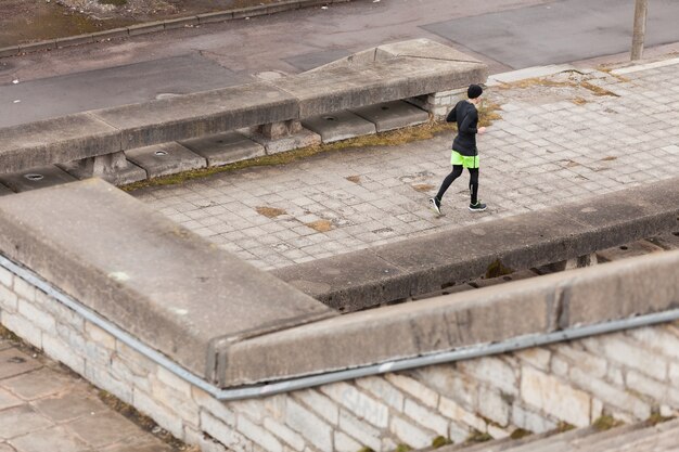 Man jogging in città piovosa