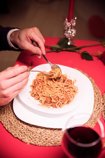 Man mangiare la pasta al tavolo festivo