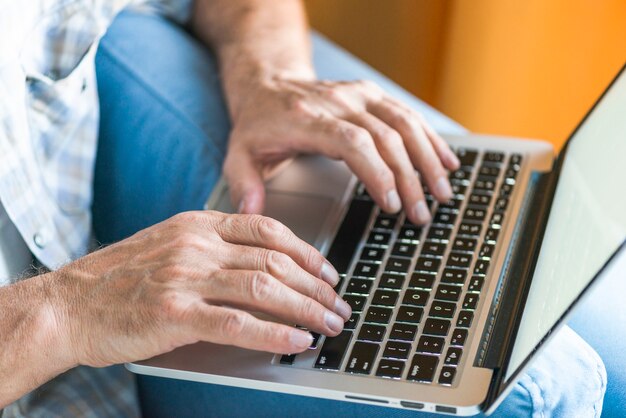 Man&#39;s hand on laptop keypad