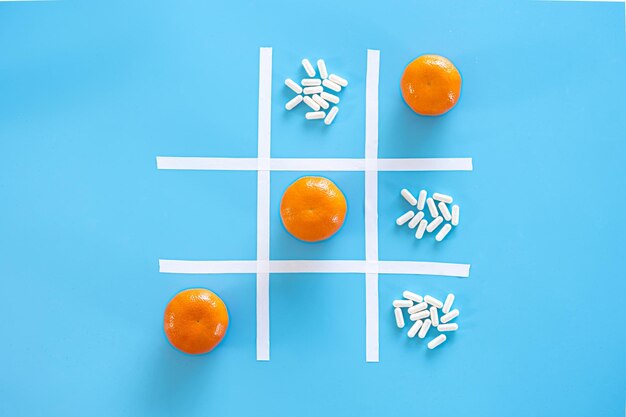 Mandarini e pillole su sfondo blu piatto