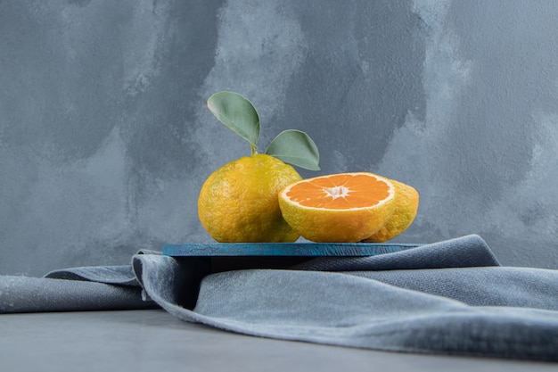 Mandarini su una tavola blu su un pezzo di stoffa, su marmo