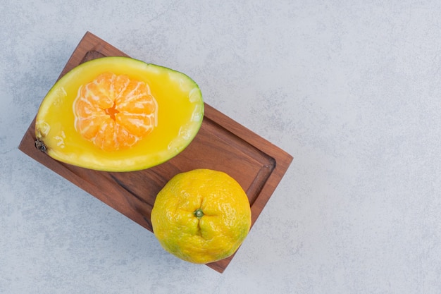 Mandarino fresco succoso e biologico su tavola di legno.