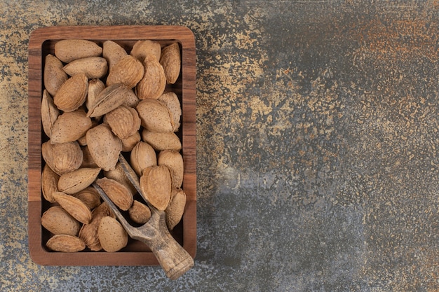 Mandorle sgusciate biologiche su piatto di legno.