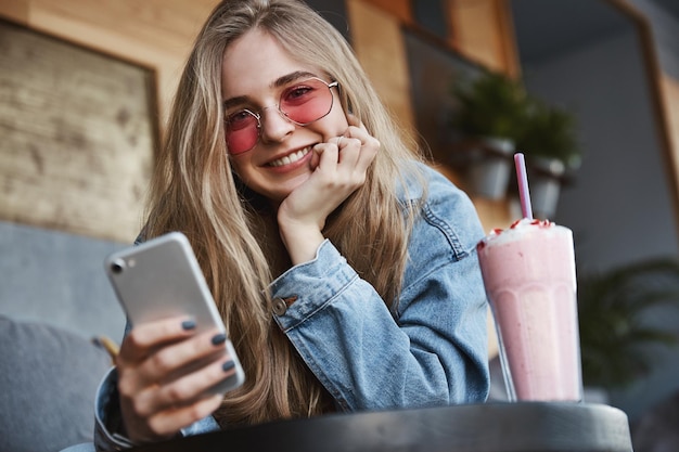 Mangiare fuori e concetto di svago Bella ragazza bionda in occhiali da sole