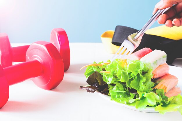 Mangiare sano, dieta, cucina vegetariana e concetto sano - close up di insalata di verdure e forchetta a casa