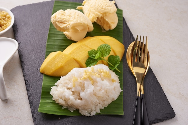 Mango maturo e riso appiccicoso, gelato con latte di cocco sulla superficie della pietra, dessert dolce tailandese nella stagione estiva. Frutta tropicale. Dessert di frutta. vista dall'alto.