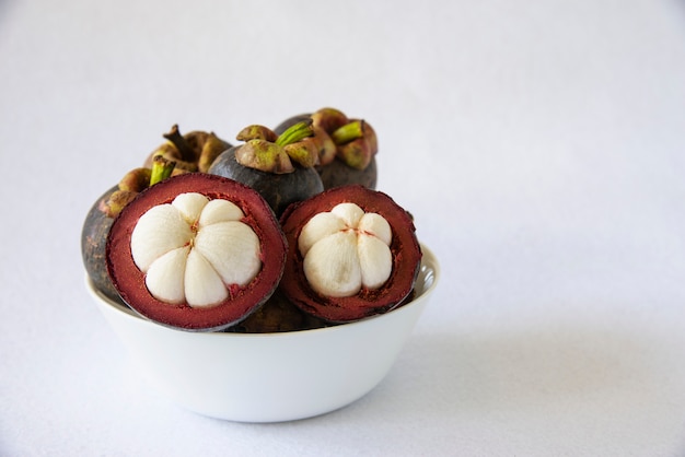 Mangosteen Frutti popolari tailandesi - un frutto tropicale con segmenti bianchi succosi e succosi di carne all&#39;interno di una spessa crosta rossiccia-marrone.