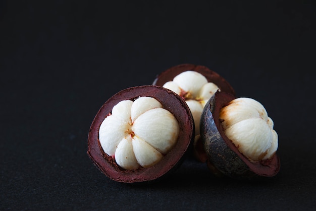 Mangosteen Frutti popolari tailandesi - un frutto tropicale con segmenti bianchi succosi e succosi di carne all&#39;interno di una spessa crosta rossiccia-marrone.