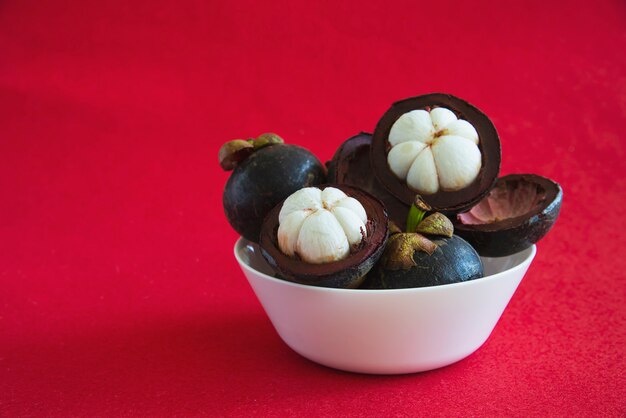 Mangosteen Frutti popolari tailandesi - un frutto tropicale con segmenti bianchi succosi e succosi di carne all&#39;interno di una spessa crosta rossiccia-marrone.