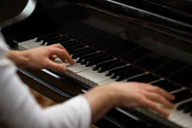 Mani ad alto angolo che suonano il pianoforte