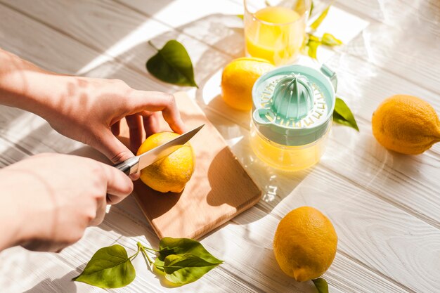 Mani ad alto angolo che tagliano il limone