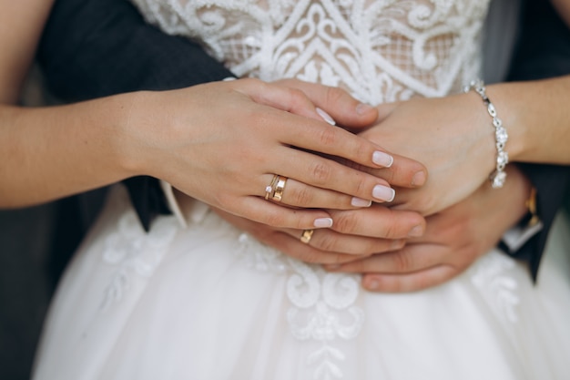 Mani appena della coppia sposata con le fedi nuziali, vista frontale, concetto di matrimonio