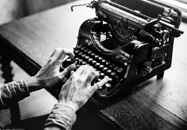 Mani che digitano la tastiera classica retrò antica della macchina da scrivere