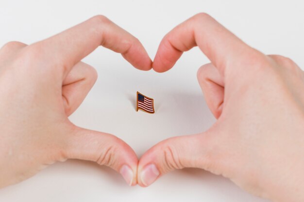 Mani che gesturing cuore e bandiera americana