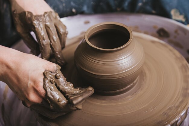 Mani che lavorano al tornio di ceramica