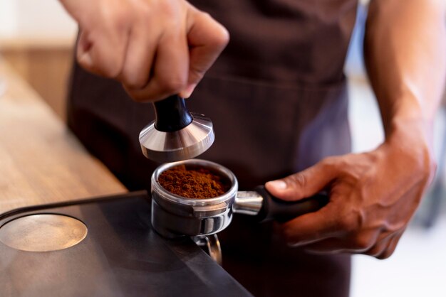 Mani che preparano il caffè da vicino