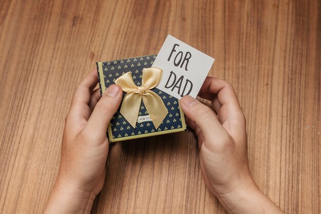 Mani che reggono un regalo di un papà