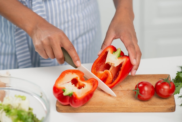 Mani che tagliano un peperone delizioso