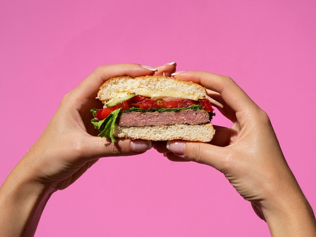 Mani che tengono hamburger gustoso americano