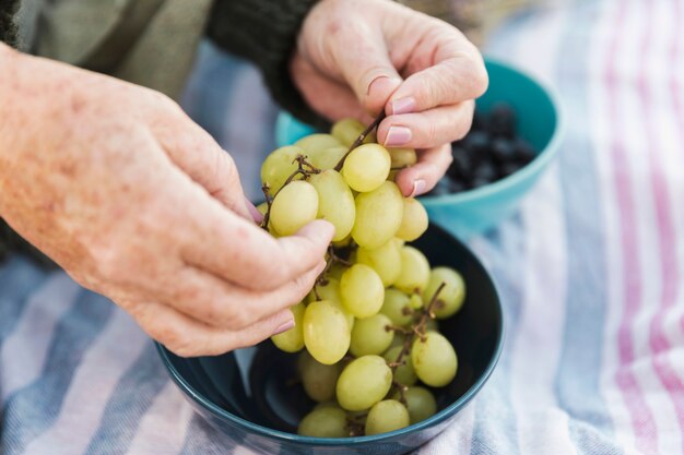 Mani che tengono l'uva fresca