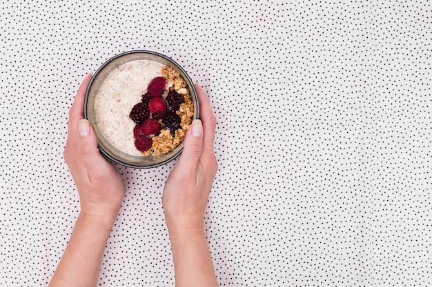 Mani che tengono la ciotola di muesli