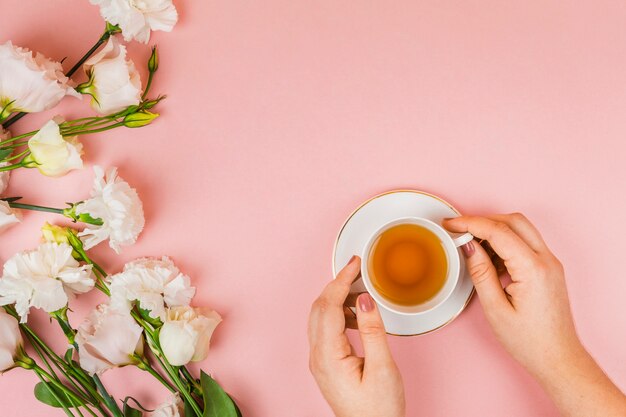 Mani che tengono la tazza di tè