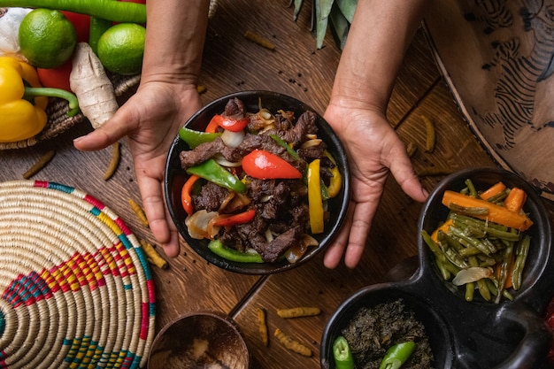 Mani che tengono una ciotola di fajita, cibo messicano