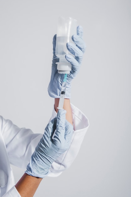 Mani con guanti e vaccino