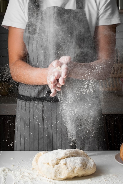 Mani d'applauso della donna con farina sopra pasta