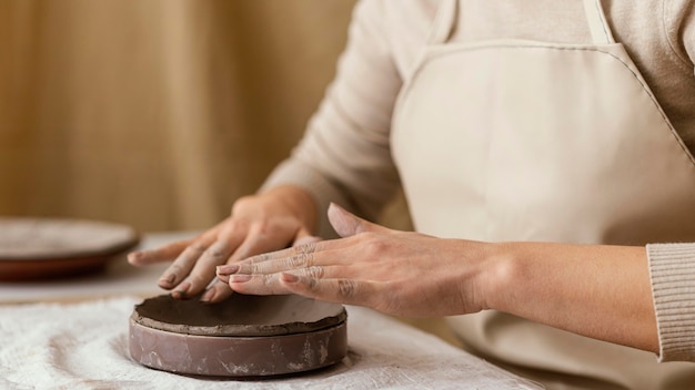 Mani del primo piano che fanno ceramiche