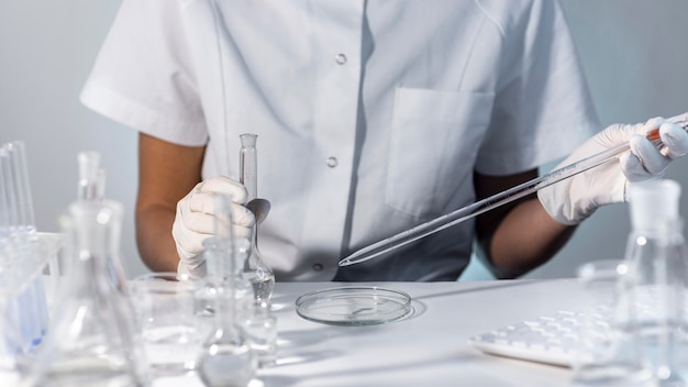 Mani del primo piano che tengono la vetreria del laboratorio