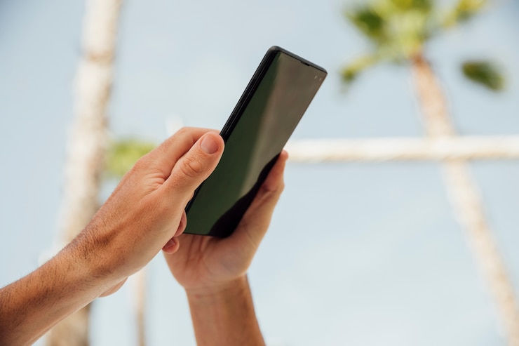 Foto gratuito mani del primo piano che tengono telefono nero