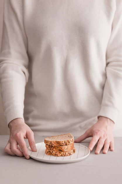 Mani del primo piano con fette di pane