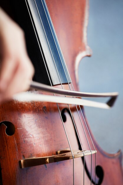 Mani del violoncellista. Violoncellist suonare il violoncello sullo sfondo del campo. Arte musicale, concetto passione per la musica. Violoncellista solista professionista di musica classica