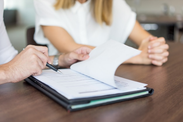 Mani dell&#39;esecutivo maschio che mostrano contratto al partner femminile alla riunione.